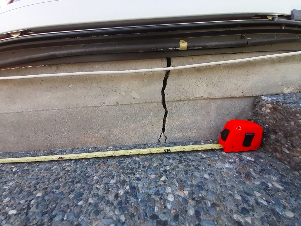 Foundation crack compared to measuring tape from a distance - True Level Concrete