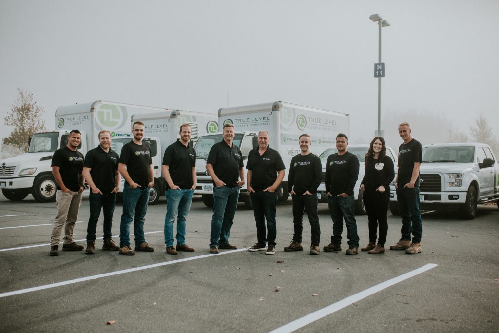 True Level Concrete team posing in front of service trucks