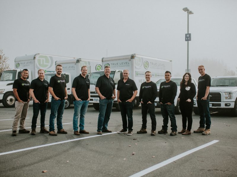 True Level Concrete team posing in front of service trucks