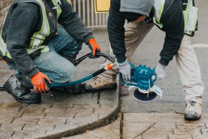 Employees assisting each other with concrete slicing