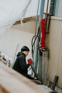 Employee holding large metal tubes