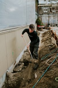 Employee using a shovel for foundation repair
