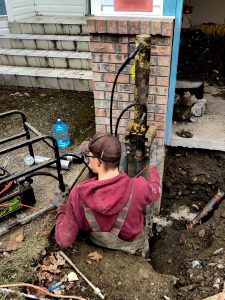 Man fixing foundation back view - Chilliwack Sunken Foundation - True Level Concrete