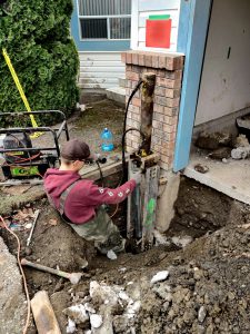Man fixing foundation side view - Chilliwack Sunken Foundation - True Level Concrete