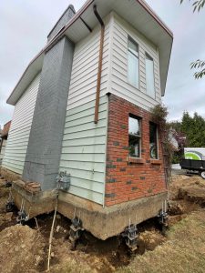 house undergoing foundation repair with piers and polylevel