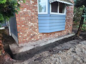 Exposed footing for piers - symptoms of settlement in Richmond home