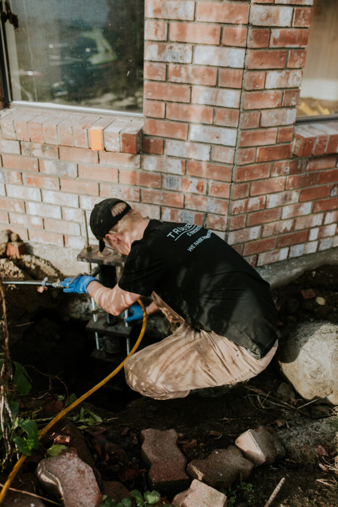 Installer fitting a pier onto the home's foundation