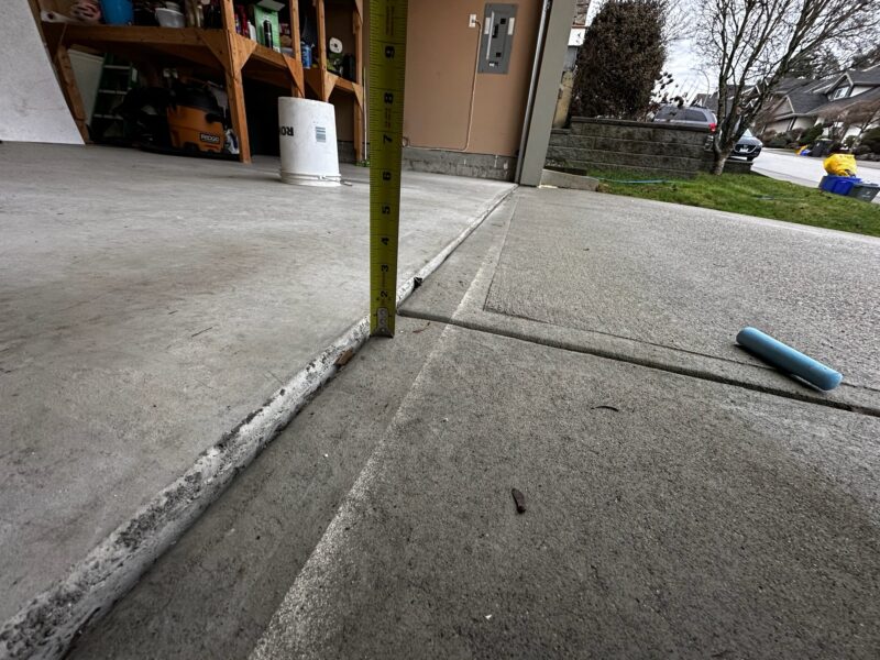 Before: Driveway slab sunken leaving gaps under the garage door