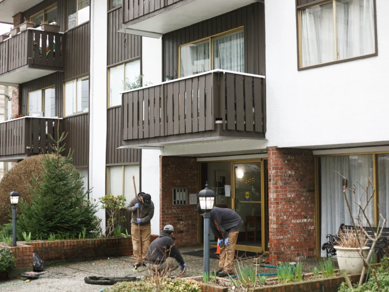 Front of Vancouver apartment building with installers working commercial concrete repair