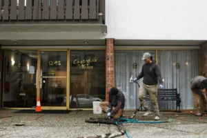 videos of Installer injecting polylevel into the concrete in front of apartment building