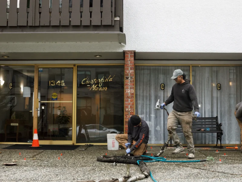 videos of Installer injecting polylevel into the concrete in front of apartment building