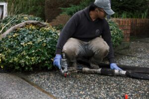 Installer injecting polylevel into the concrete in front of apartment building