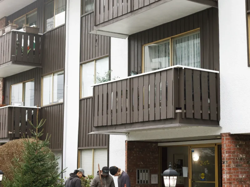 Installer injecting polylevel into the concrete in front of apartment building