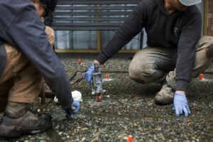 Installer injecting polylevel into the concrete in front of apartment building