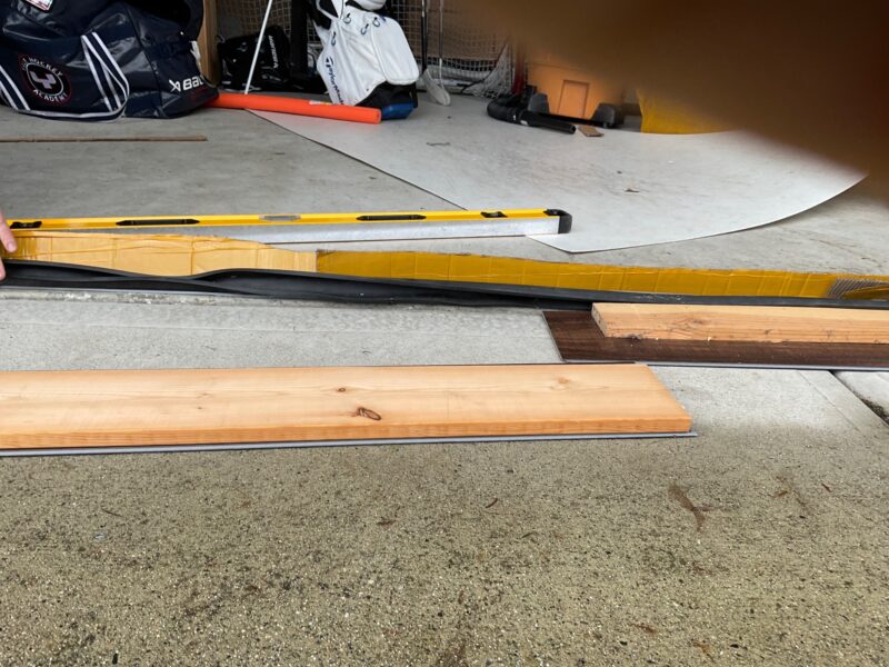 Before: Homeowner uses wooden planks to fill the voids under garage door