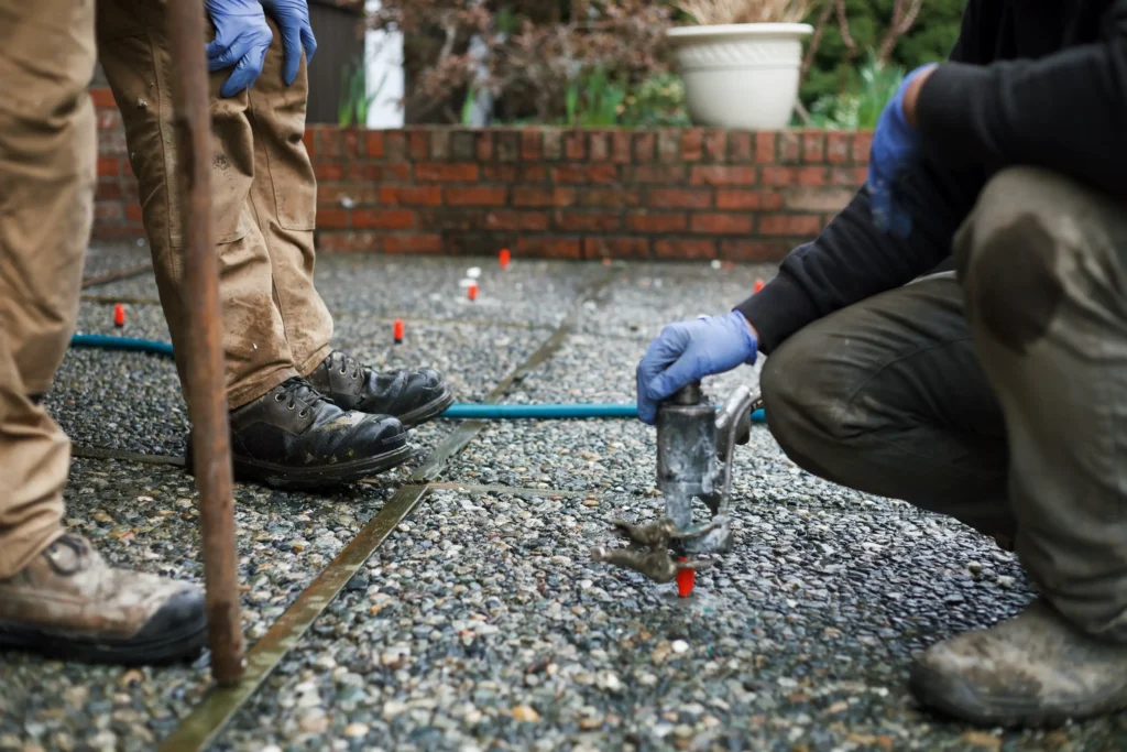 Installer injecting polylevel into the concrete in front of apartment building