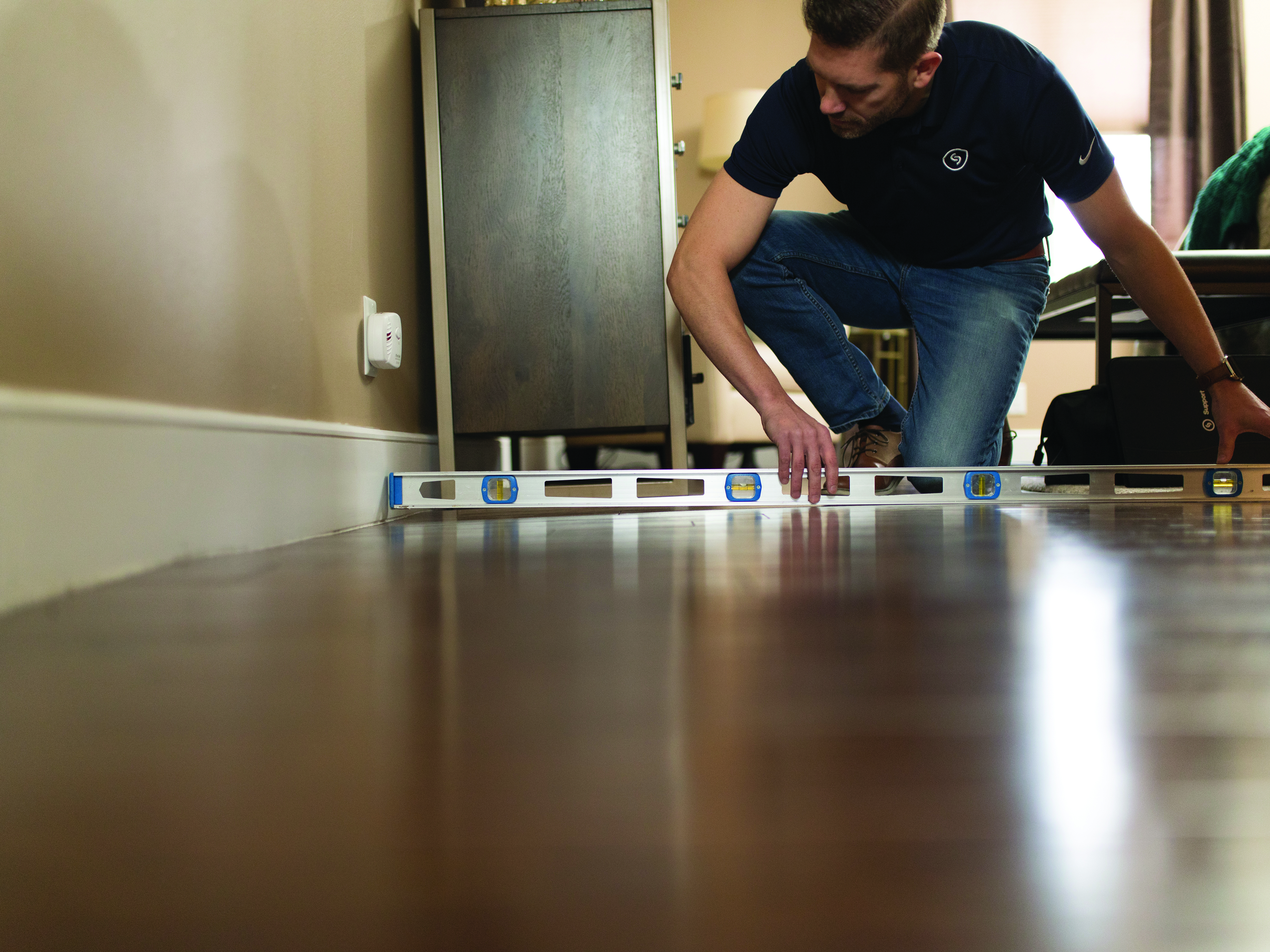 sunken floor uneven floor with man holding a level