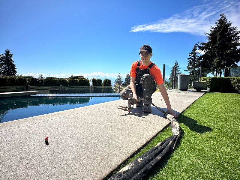 crew member injecting polylevel into pool deck
