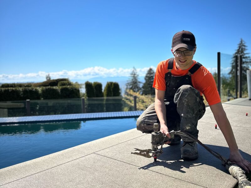crew member injecting polylevel into pool deck