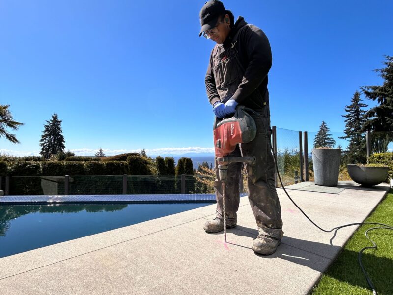 crew member drilling into pool deck