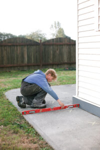 installer measuring sidewalk levels