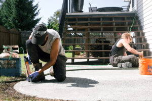installer doing crack repair on a patio